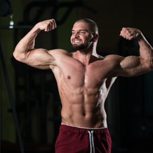 Muscular Man Flexing Muscles In Gym Stock Photo - Download Image Now