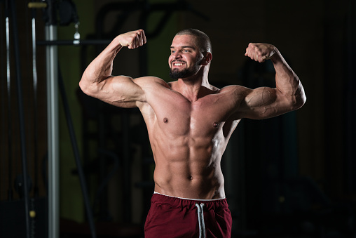 bersa-bpcc-concealed-carry-9mm-luger-3-3in-olive-black-81-rounds-muscular-man-flexing-muscles-in-gym Muscular Man Flexing Muscles In Gym Stock Photo - Download Image Now